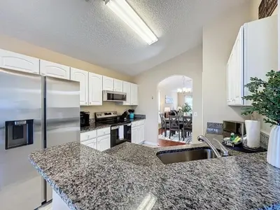a kitchen with white cabinets and a counter top at Emerald Island Four Bed Pool Home close to Disney villa in Kissimmee