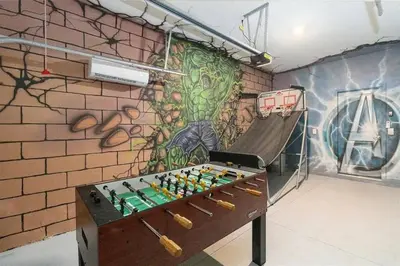 a room with a foosball table in front of a wall at Fantastic Home 7BR5BA with Private Pool Storey Lake Resort SL2648 in Kissimmee