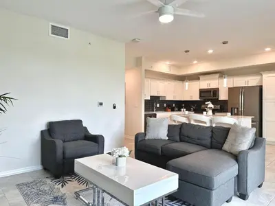 a living room with two chairs and a couch and a table at 2 Bedroom Condo minutes from Disney 325 in Kissimmee
