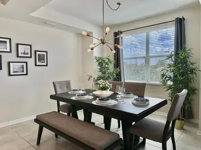 a black dining room table with chairs and a window at My condo 2bd 2bth close to Disney World 315 in Kissimmee
