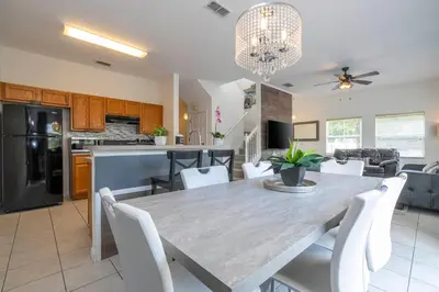 a dining room and kitchen with a table and chairs at 4 bedrooms close to Disney in Kissimmee