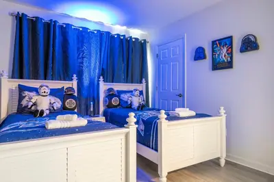 two twin beds in a room with blue curtains at 4 bedrooms close to Disney in Kissimmee