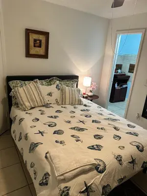 a bed with a comforter and pillows in a bedroom at Private Studio in Kissimmee