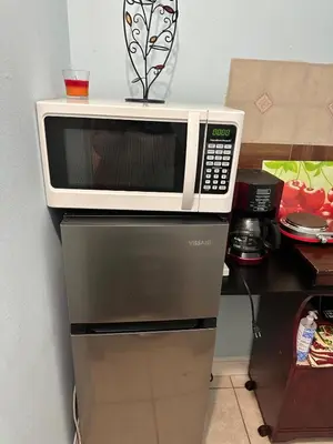 a microwave sitting on top of a refrigerator at Private Studio in Kissimmee