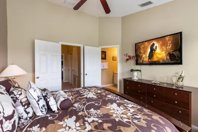 a bedroom with a large bed with a tv on the wall at Escape to Luxury in Orlando Villa6492 in Orlando