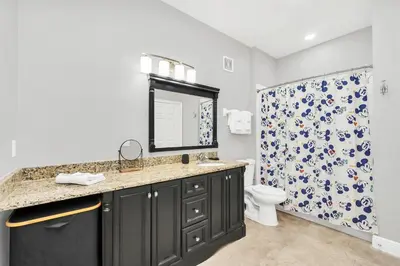 a bathroom with a sink and a toilet and a mirror at Serene 3 Bedroom Retreat in Orlando6494 in Orlando