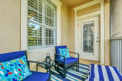 a porch with two blue chairs and a window at Serene 3 Bedroom Retreat in Orlando6494 in Orlando