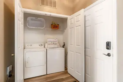 a small laundry room with a washer and dryer at Stunning 2 Bedroom Retreat in Orlando6496 in Orlando