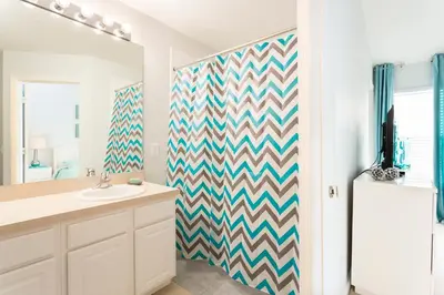 a bathroom with a chevron patterned shower curtain at Cozy 3 Bedroom Haven in Orlando6497 in Orlando