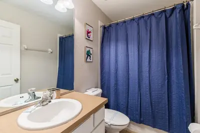 a bathroom with a sink and a blue shower curtain at Charming Orlando Villa with 5 Bedrooms6499 in Orlando