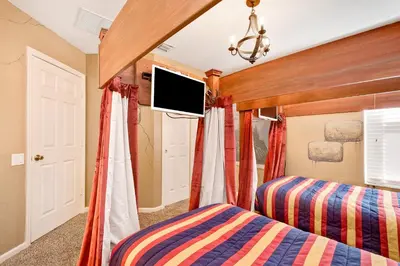 a bedroom with two beds and a flat screen tv at Orlando Oasis: 5 Bedroom Villa6502 in Orlando