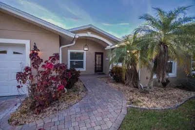 a house with palm trees and a driveway at Lakefront and Pool 4bed Orlando House Near Downtown 20 minutes from Attractions in Orlando