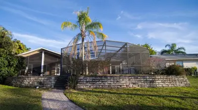 a palm tree in front of a glass house at Lakefront and Pool 4bed Orlando House Near Downtown 20 minutes from Attractions in Orlando