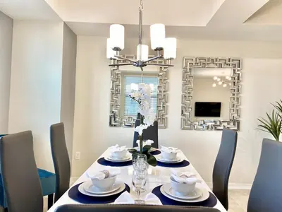 a dining room with a table with chairs and a mirror at Luxury 2bd 2 bath Condo Home 250 in Kissimmee