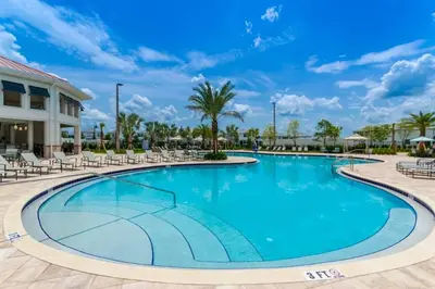a swimming pool at a resort with chairs and palm trees at Luxury 2bd 2 bath Condo Home 250 in Kissimmee