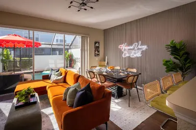a living room with a couch and a dining room at Magical Getaway Close to Disney with Heated Pool in Orlando
