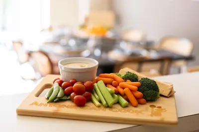 a tray of vegetables on a table with a dipping sauce at Magical Getaway Close to Disney with Heated Pool in Orlando