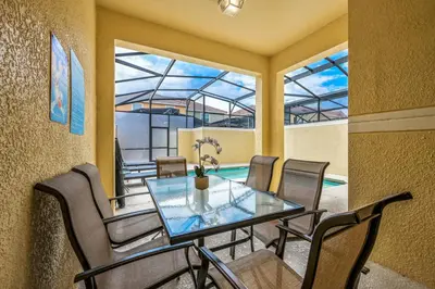 a dining room with a glass table and chairs at PP8962 - 4 Bedrooms w Pool & Resort Access in Kissimmee