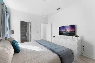 a white bedroom with a large bed with a flat screen tv at New Listing - Be the First Guest 5 BR - BV468 in Kissimmee