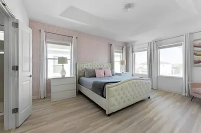 a bedroom with a bed with a couch and windows at New Listing - Be the First Guest 5 BR - BV468 in Kissimmee