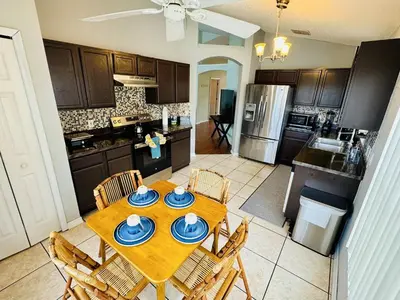 a kitchen with a wooden table with chairs and a kitchen with a tableablish at Private Pool House With Lake View, Near All Famous Attractions!!! in Kissimmee