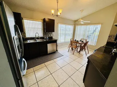a kitchen with a sink and a table with chairs at Private Pool House With Lake View, Near All Famous Attractions!!! in Kissimmee