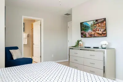 a bedroom with a bed and a blue chair at Themed 5Bd Paradise Palms Close to Disney w Pool 8951 in Kissimmee