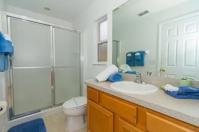 a bathroom with a sink and a toilet and a mirror at Beautiful 4 Bed In Prime Location in Kissimmee