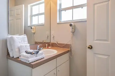 a bathroom with a sink and a mirror at Charmosa 3Q/2.5B c/Jacuzzi * Vista Lago * in Kissimmee