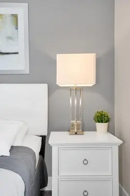 a white nightstand with a lamp on it next to a bed at NEW amazing unique dream house 5 Min to Disney in Orlando