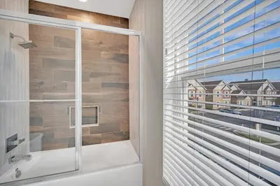 a bathroom with a shower and a glass window at NEW amazing unique dream house 5 Min to Disney in Orlando