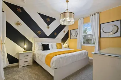 a bedroom with a large bed and a chandelier at Top Luxury Villa Storey Lake mins to Disney in Kissimmee