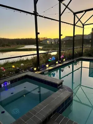 a large swimming pool with a view of the water at Top Luxury Villa Storey Lake mins to Disney in Kissimmee