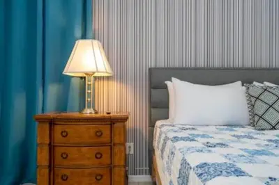 a lamp on a night stand next to a bed at Amazing 5 BR wgame room minutes from Disney in Kissimmee