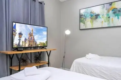 a living room with a flat screen tv on a wall at Amazing 5 BR wgame room minutes from Disney in Kissimmee
