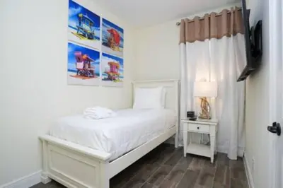 a white bedroom with a white bed and a window at BRAND NEW Cozy 3BR Margaritaville in Orlando