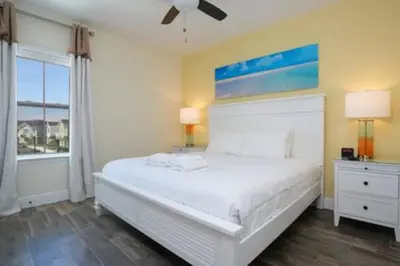 a bedroom with a white bed and a window at BRAND NEW Cozy 3BR Margaritaville in Orlando