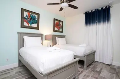 a bedroom with two beds and a ceiling fan at BRAND NEW Private Oasis 4 BR - Margaritaville in Orlando