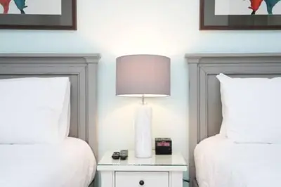 a bedroom with two beds and a table with a lamp at BRAND NEW Private Oasis 4 BR - Margaritaville in Orlando
