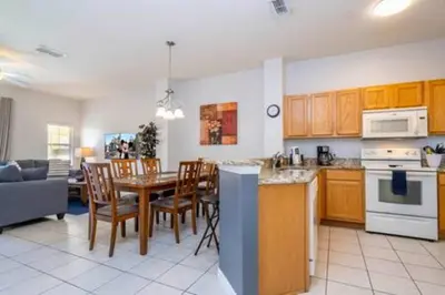 a kitchen and living room with a table and chairs at Cozy 3 BR wprivate pool in Kissimmee