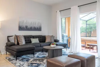 a living room with a couch and a table at Cozy 4BR Regal Oaks close to Disney in Orlando