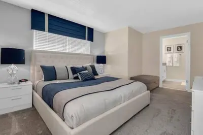 a bedroom with a large bed with blue accents at Storey Lake Resort 5BD Private Pool Close to Disne in Kissimmee