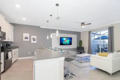 a kitchen and living room with a couch and a table at Gorgeous Storey Lake 4BR in Kissimmee