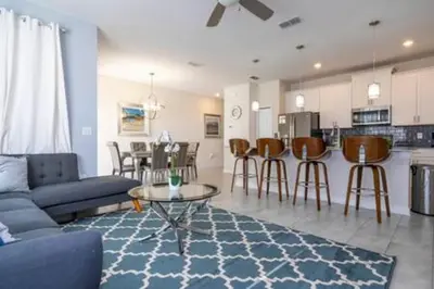 a living room with a couch and a table and a kitchen at Gorgeous Home with pool and lake view in Kissimmee
