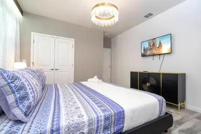 a bedroom with a bed and a chandelier at Stunning 15 suites close to Disney in Kissimmee