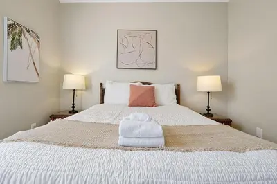 a bedroom with a white bed with towels on it at Windsor Palms Home - Pool, Theatre &Near Disney in Kissimmee