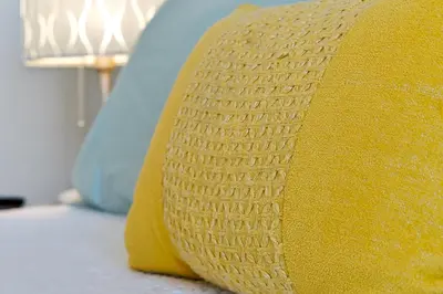 a yellow pillow sitting on top of a bed at Windsor Palms Home - Pool, Theatre &Near Disney in Kissimmee
