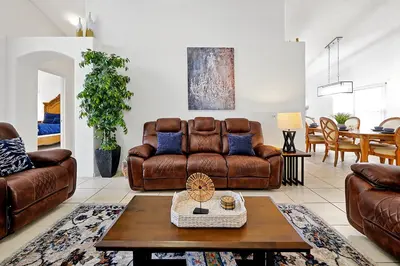 a living room with a couch and a table at Private Pool Home Near Disney & Universal Studios in Kissimmee