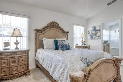 a bedroom with a large bed with blue pillows at Private Pool Home Near Disney & Universal Studios in Kissimmee
