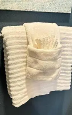 a stack of white towels on a rack at Whimsical Condo 1.5M from Disney in Orlando